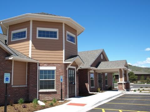 Finished brick and lap-siding building with an octagonal tower and a covered entry