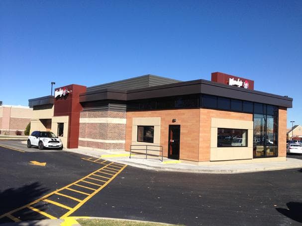 Wendy's restaurant with brick, tan block and a red sign tower under a blue sky